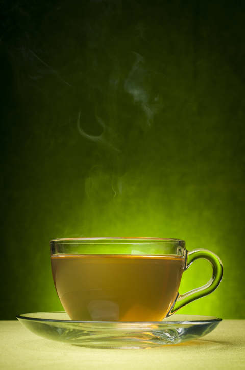 Tasse mit heißem, dampfenden grünem Tee