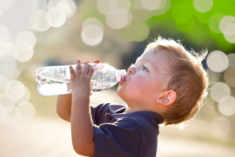 Kind trinkt Wasser aus einer Flasche
